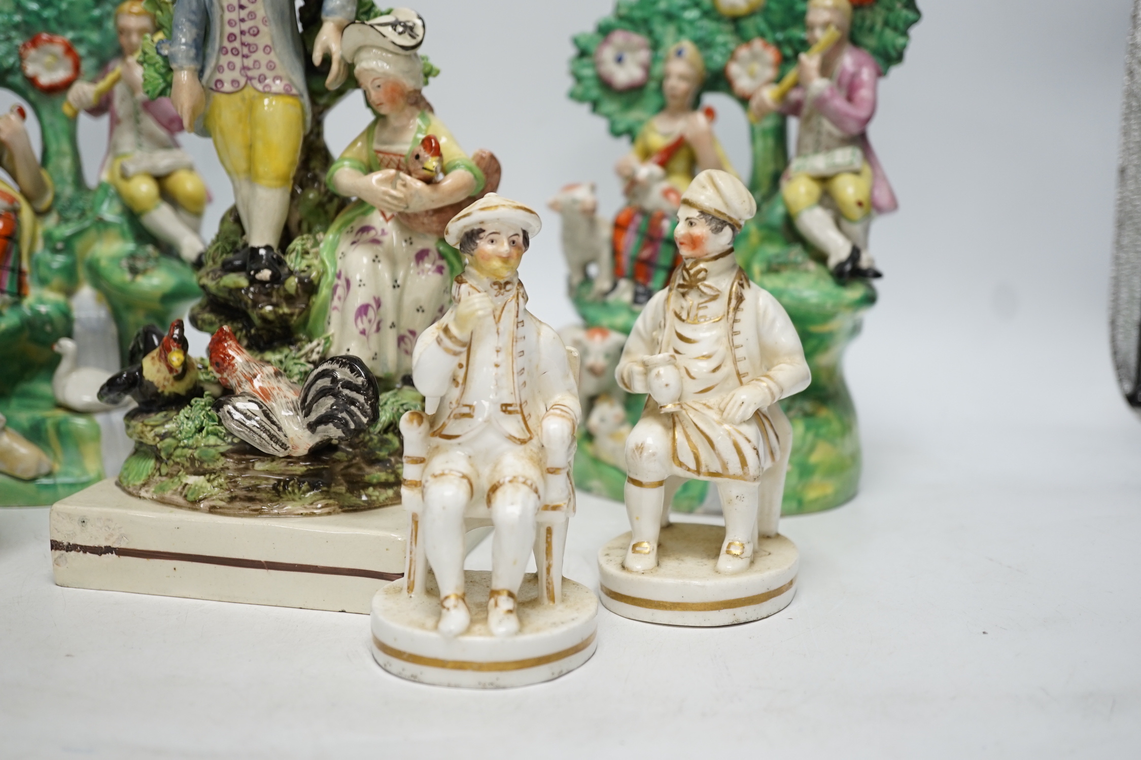 A Staffordshire pottery group of two figures with chickens, c.1800-10, a pair of early 20th century Staffordshire pottery figure groups and three small character figures, tallest 25cm high (6)